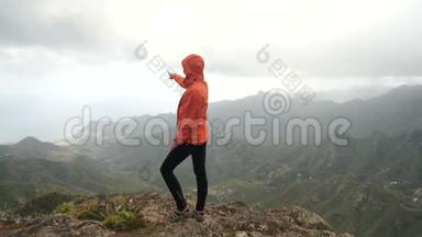 年轻女子站在山顶上的仙人掌和热带植物在美丽的风景。 夫人在